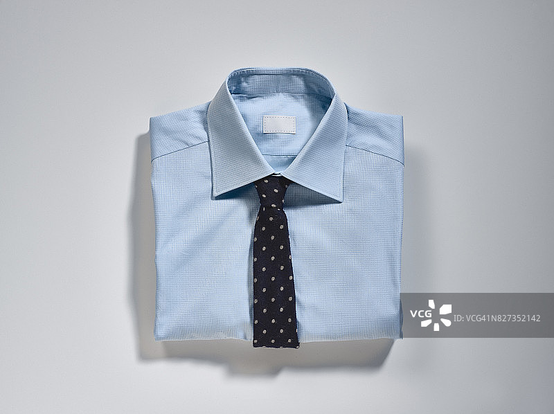 浅蓝色衬衫，领带，手帕和袖口链，工作室拍摄的灯光背景图片素材