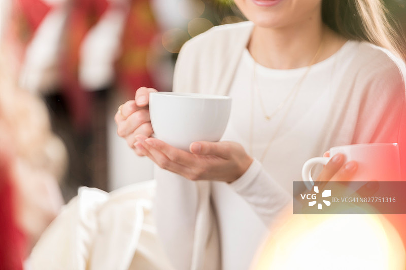 圣诞节期间，一个面目全非的女人端着一杯咖啡图片素材