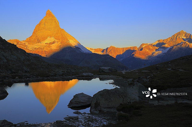 童话般的景观-马特洪湖倒影和金色的黎明日出:田园诗般的高山山谷和梦幻般的戏剧性瑞士雪山国家象征，田园诗般的乡村，瓦莱州，瑞士阿尔卑斯山，瑞士图片素材