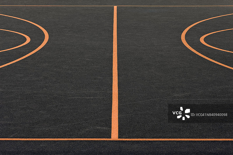 室外篮球场用格子图案覆盖，有各种橙色的球场线。图片素材