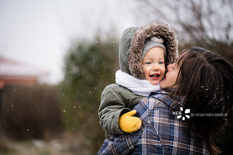 微笑的女婴和母亲在冬季公园图片素材