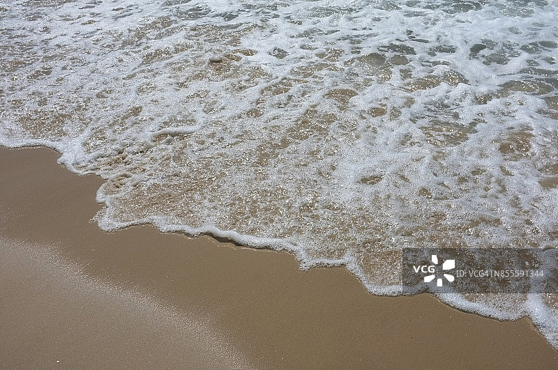 海浪和海沫到达岸上图片素材