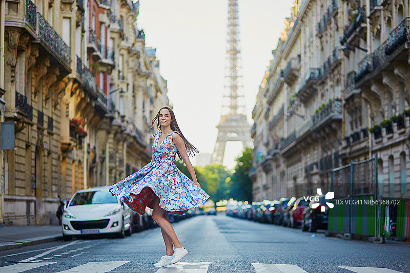拿着彩色气球的女孩跑过巴黎的街道图片素材