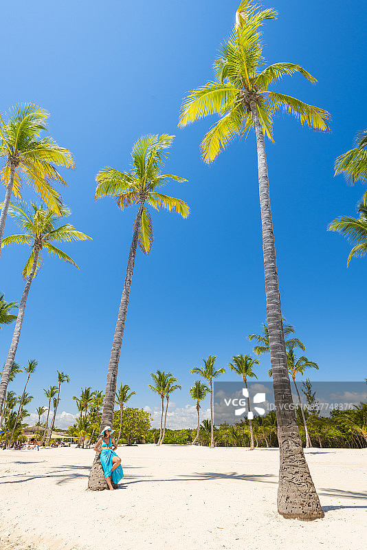 游客休息在一棵棕榈树在Juanillo海滩，多米尼加共和国。图片素材