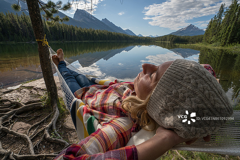 年轻女子在湖边的吊床上休息图片素材