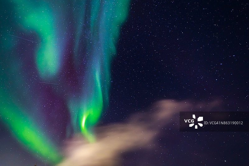 格陵兰努克，绿色北极光在星星和云之间的天空中发光图片素材