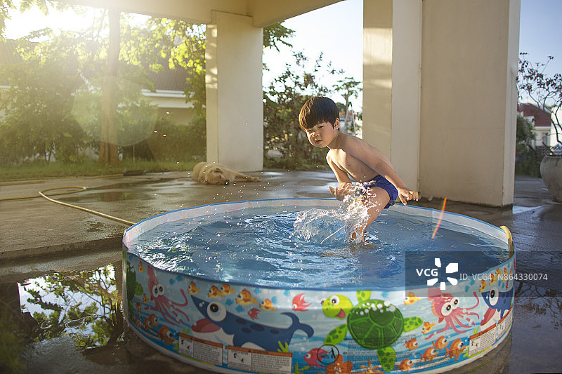 东亚的小男孩在夏天玩水。图片素材