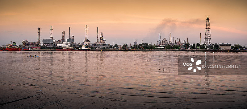 炼油厂全景石油和天然气工业-炼油厂在日出-工厂-石化厂与反射河图片素材