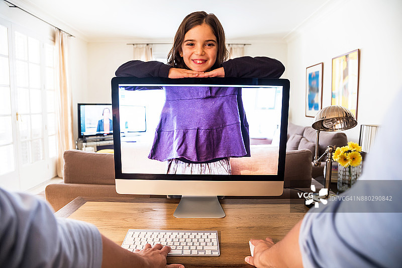 这是一个带着个人视角在家工作的人的创意图片，孩子在透明的屏幕电脑后面玩，在一个原创的想法中玩透视。图片素材