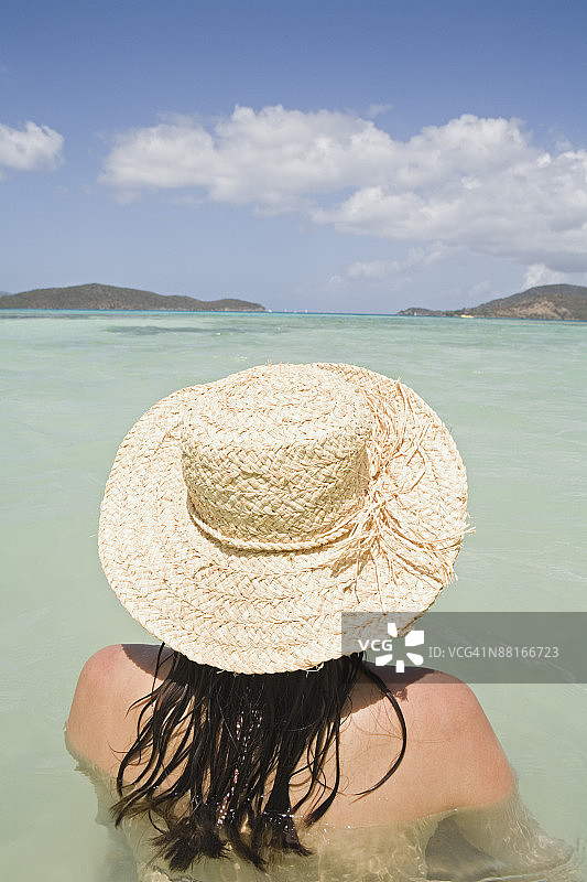 大海里戴着草帽的女人图片素材