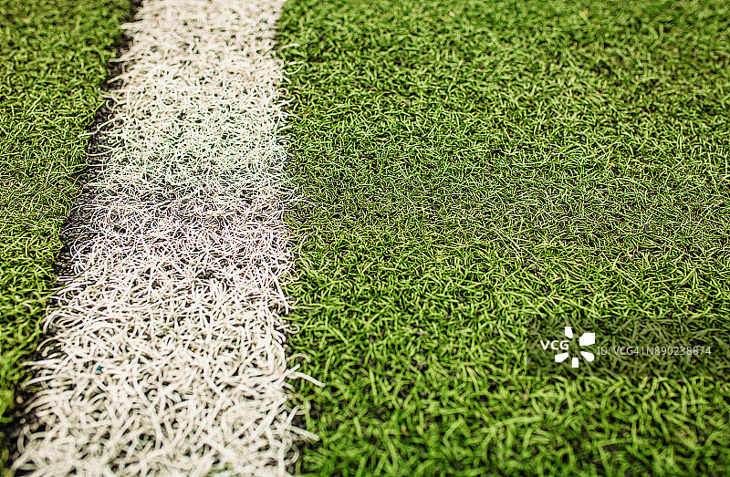 绿色的人造草地足球场。绿色足球场背景上的白线。图片素材