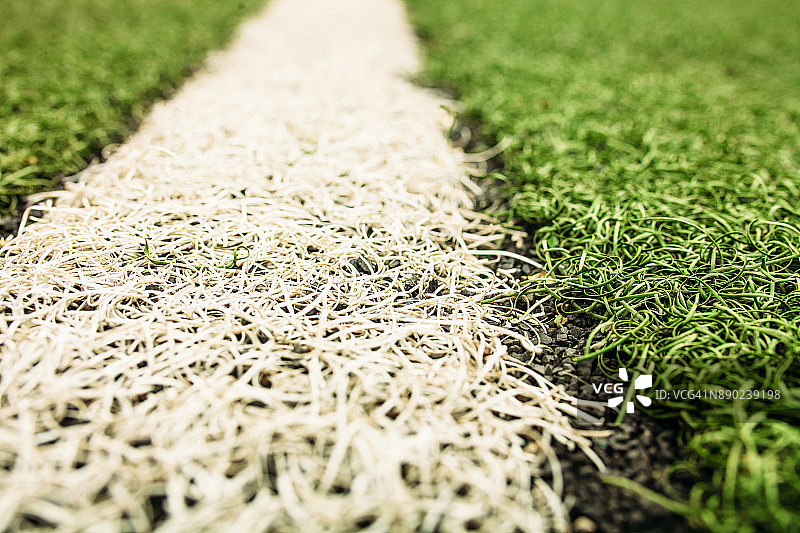 绿色的人造草地足球场。绿色足球场背景上的白线。图片素材
