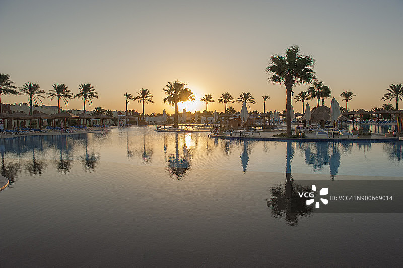 日出时在一个豪华热带酒店度假的大型游泳池图片素材