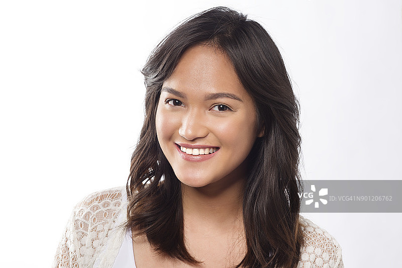 一个年轻快乐的亚洲女士穿着白色上衣的肖像，拍摄在一个工作室的背景图片素材