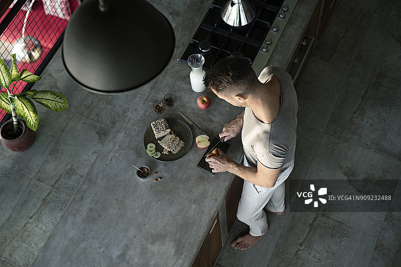 成熟的男人站在厨房里，准备健康的早餐图片素材