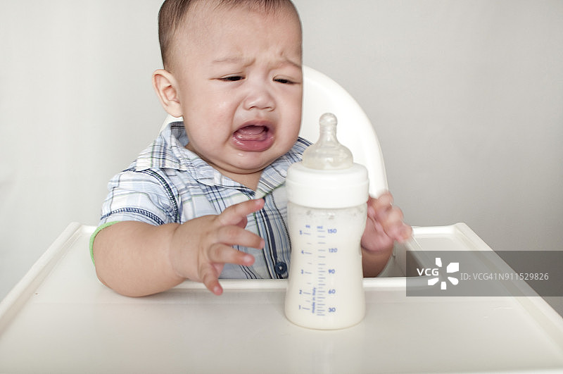 婴儿正在自己吃配方奶粉图片素材