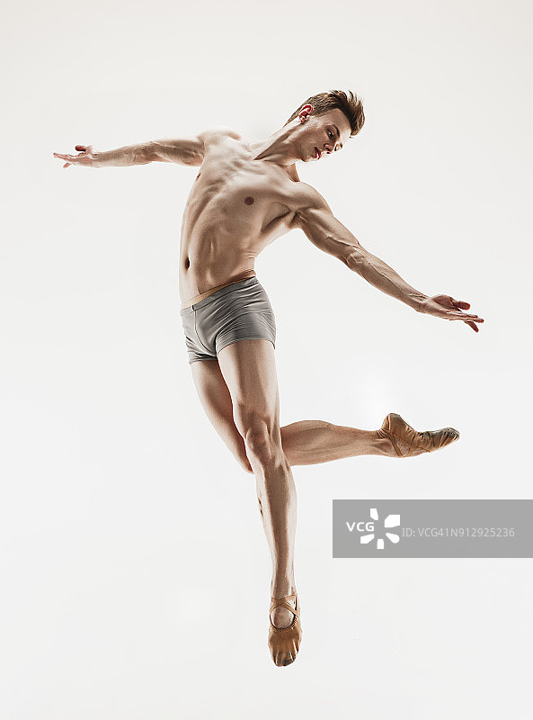 身材完美的芭蕾舞演员在灰色背景上表演图片素材