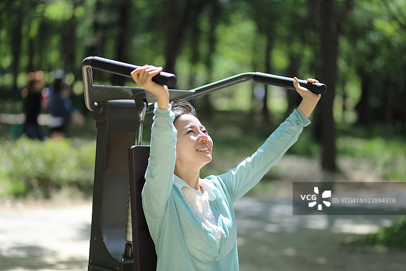 中年妇女在公园里使用健身器图片素材