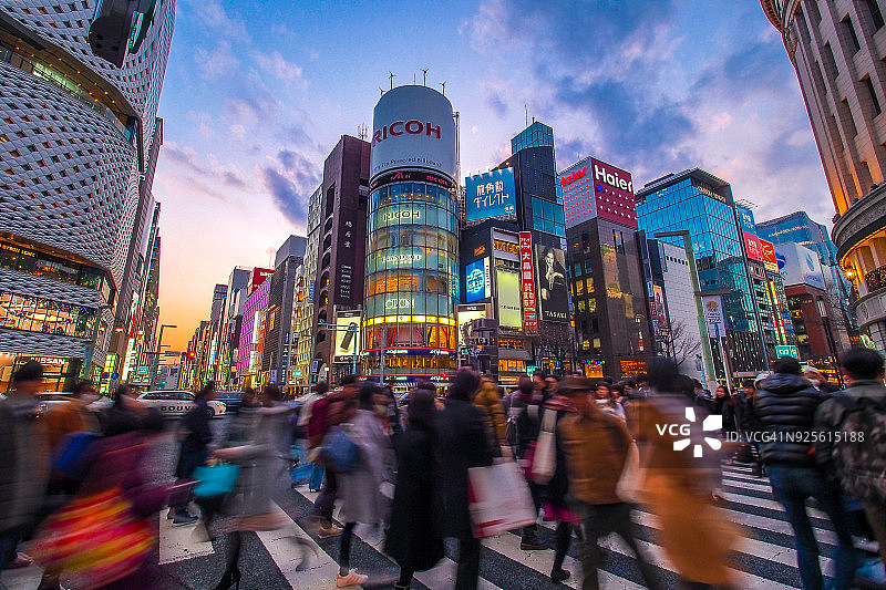 在日本东京市中心，霓虹招牌下的奢侈品购物街，银座大街上排列着昂贵品牌的商店图片素材
