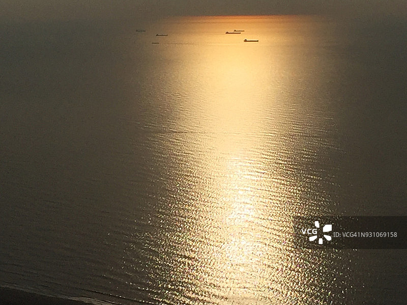 鸟瞰图在日出的船只在一个微光的海面上远离纽约市海岸图片素材