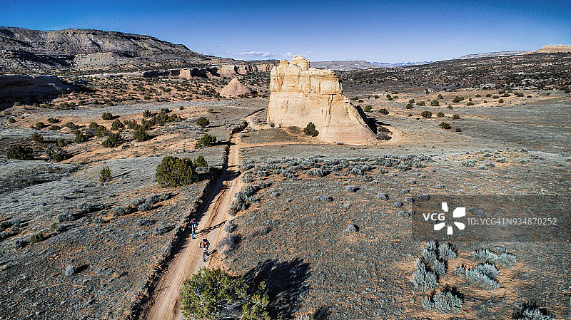 两个人骑着山地车走在沙漠中的一条沙地上图片素材