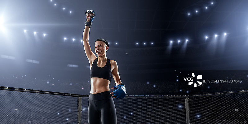 女子综合格斗选手在职业拳击台上为胜利而欢呼图片素材