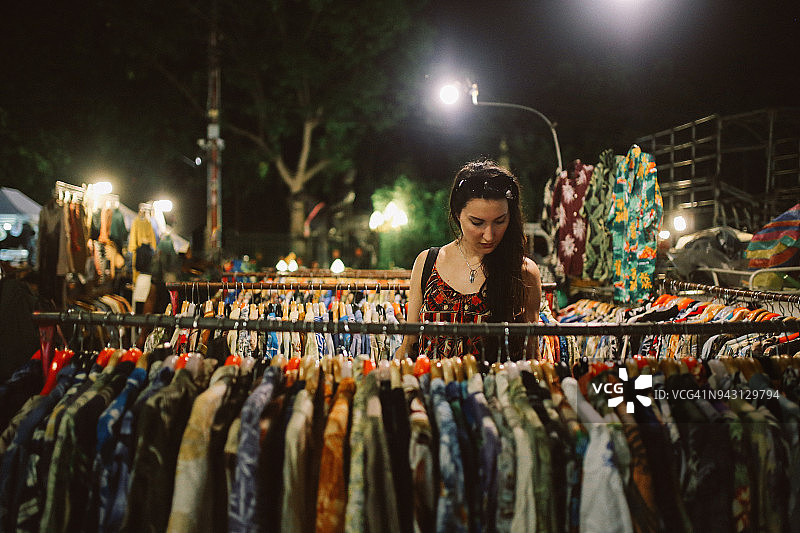 年轻女子在曼谷街头市场浏览夏威夷衬衫图片素材