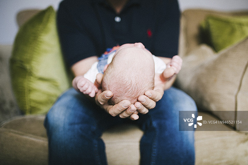 刚出生的婴儿被她的父亲抱着图片素材