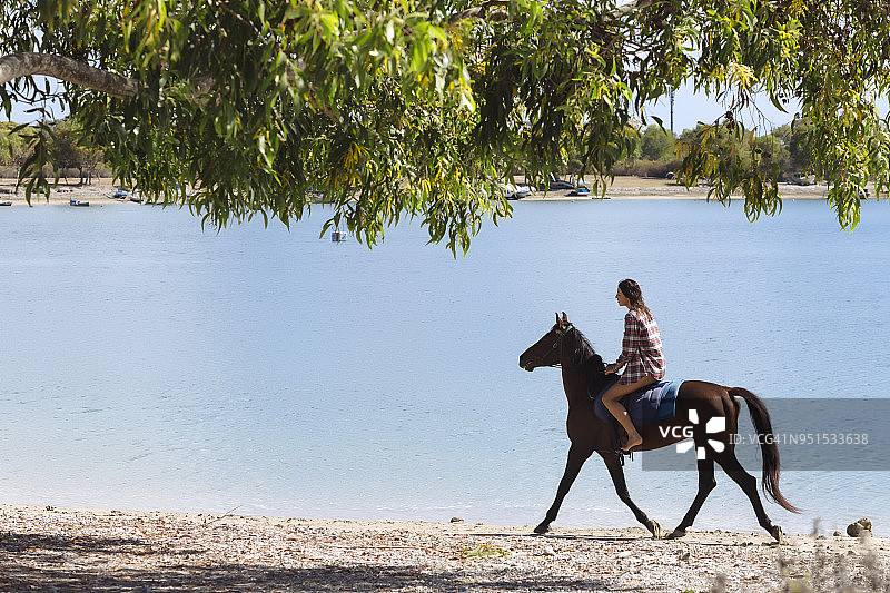 印度尼西亚，巴厘岛，在海滩上骑马的女人图片素材