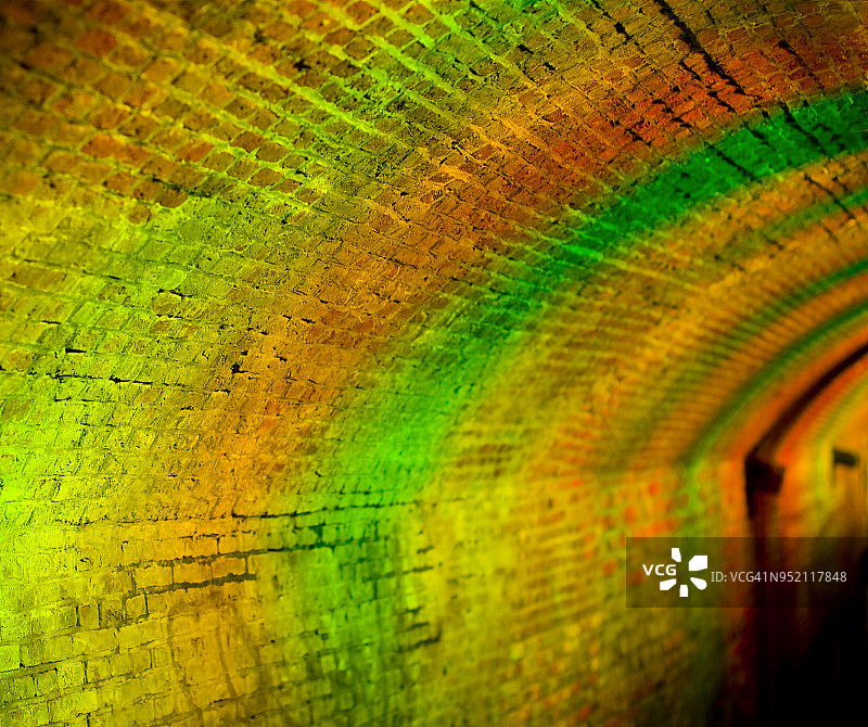 在隧道里的夜晚，橙色和绿色的光被散焦图片素材
