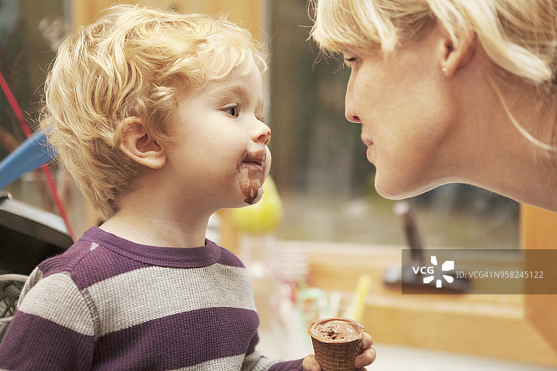 男孩吃冰淇淋的特写，看着妈妈图片素材