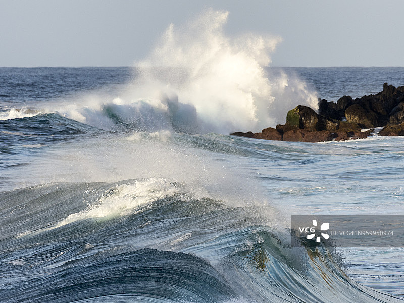一股巨浪对葡萄牙亚速尔群岛特塞拉岛海岸或海滩上的火山岩的影响。图片素材