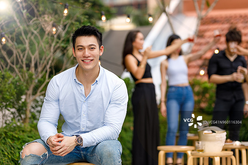 年轻的亚洲男子享受户外屋顶派对与朋友图片素材