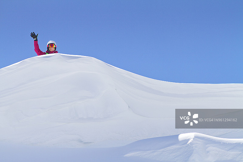 女人的肖像在雪山上挥手反对晴朗的天空图片素材