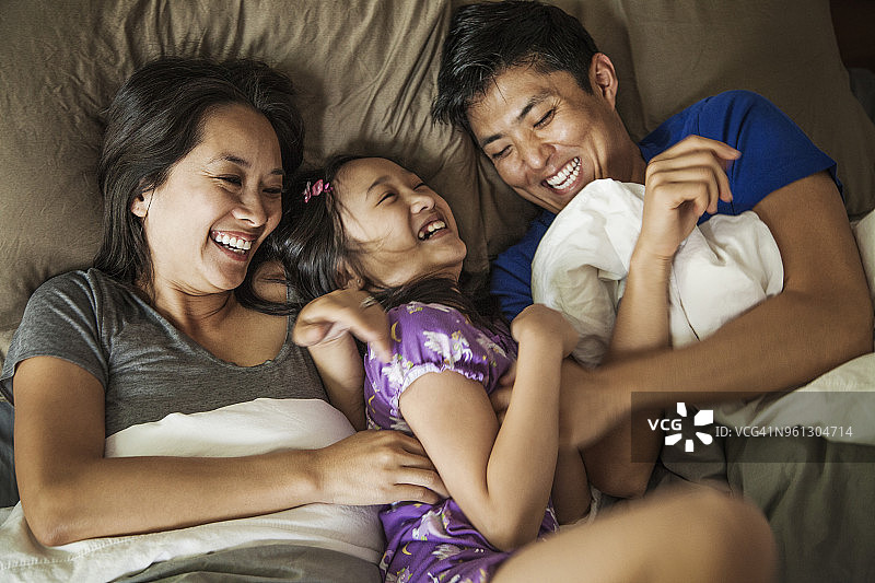 头顶上的幸福家庭在床上在家图片素材