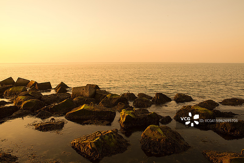 日落时海里的石头(荷兰角，荷兰)图片素材