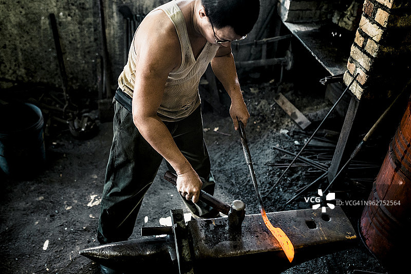 铁匠用锤子打铁图片素材