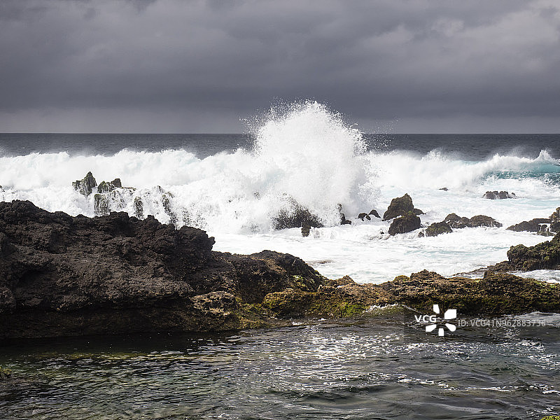 葡萄牙亚速尔群岛特塞拉岛海岸的海洋景观与天空的风暴，海浪冲击的火山岩。图片素材