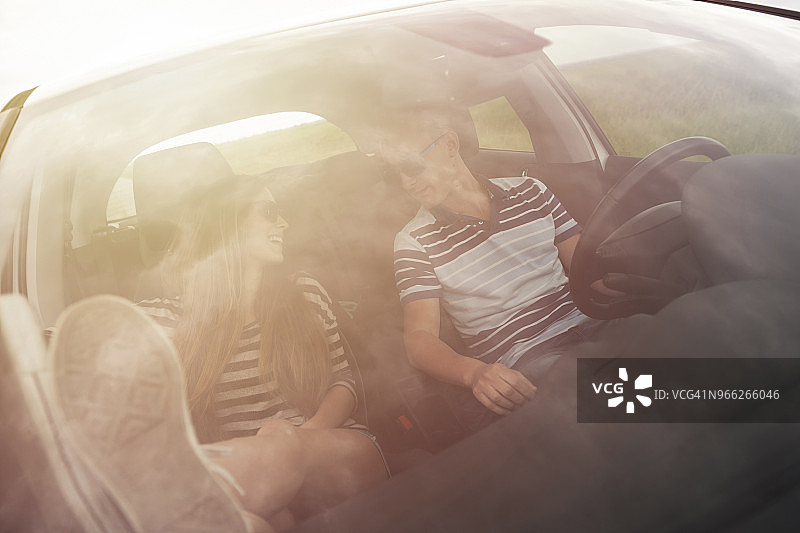 透过挡风玻璃可以看到坐在车里聊天的夫妇图片素材