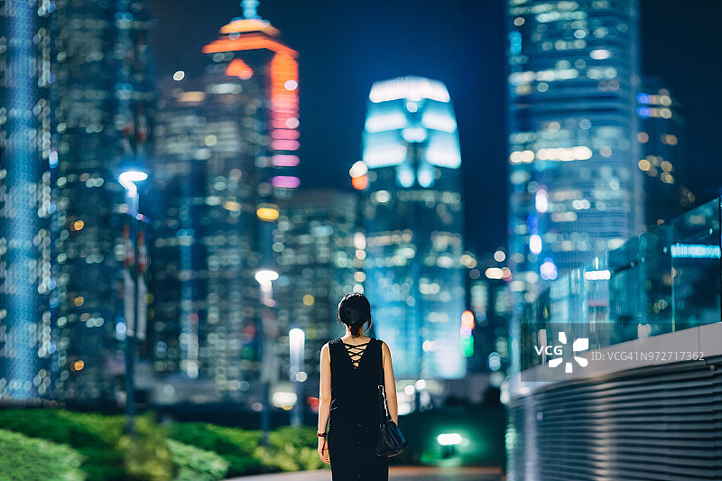 后视图的妇女望向现代金融摩天大楼在市中心的香港图片素材