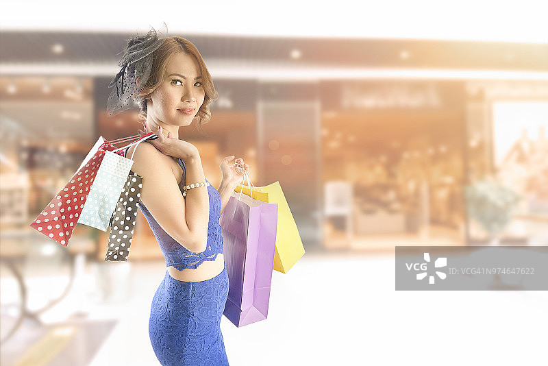 亚洲女人拿着高档购物袋在购物中心图片素材
