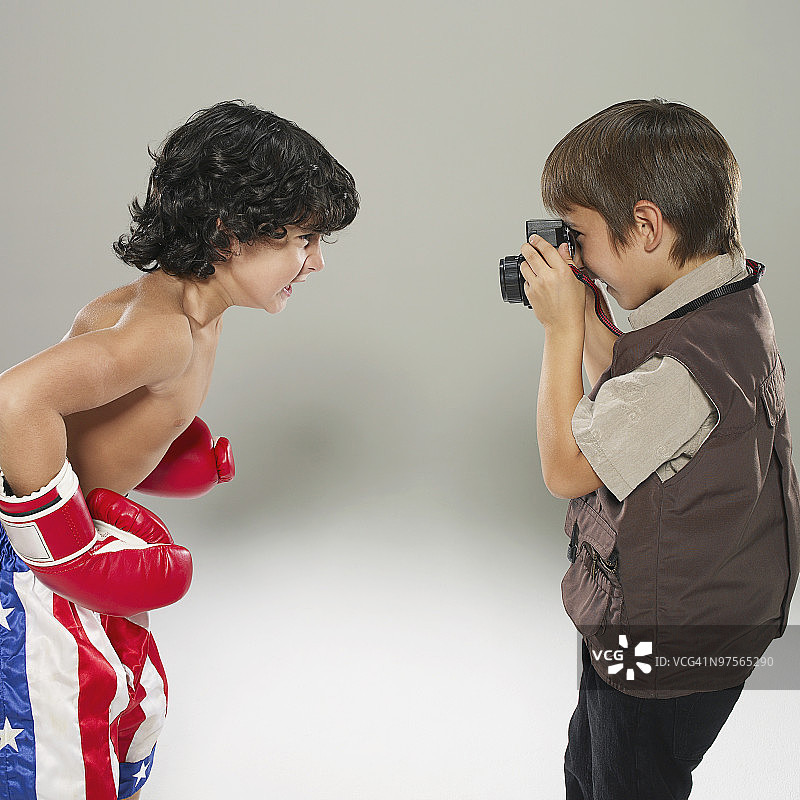 一个男孩在给一个拳击手拍照图片素材