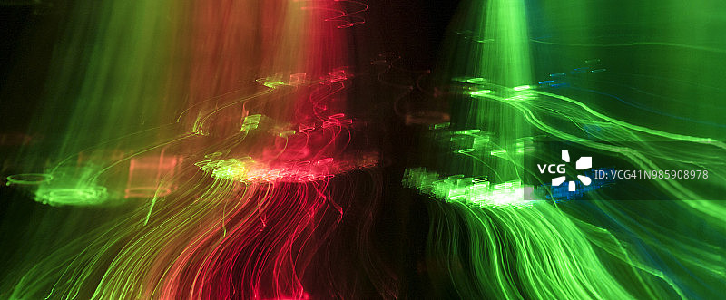近距离抽象图案交织的彩色光束红色和绿色的黑色背景。图片素材
