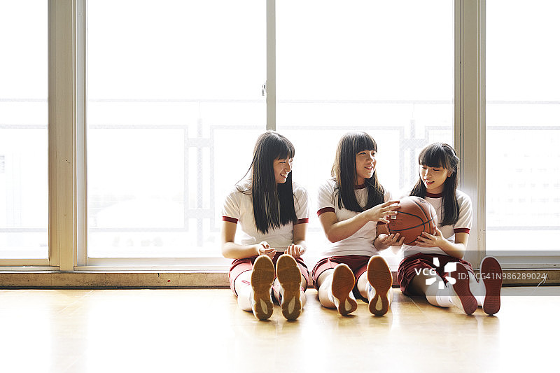 日本初中女生在体育馆的角落里聊天图片素材