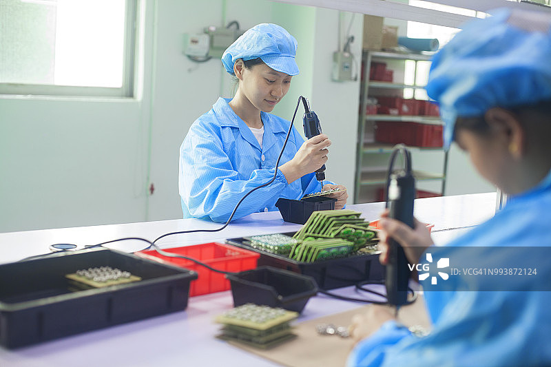 在中国东莞一家LED照明元件工厂，身着制服的女工们图片素材