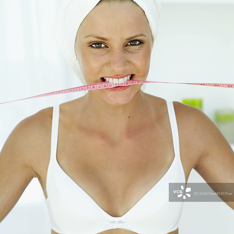 一个女人拿着一个测量尺在她的嘴的特写镜头图片素材