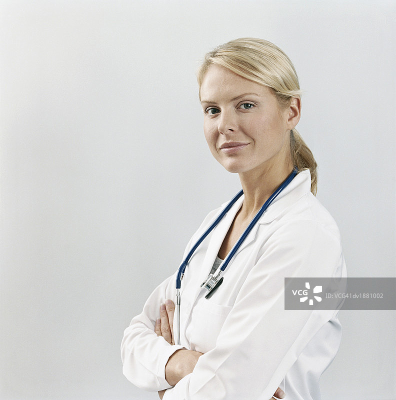 一个自信的年轻医生与她的双臂交叉的肖像图片素材
