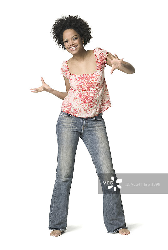 全身拍摄的年轻成年女性在印花衬衫，因为她开玩笑地跳舞图片素材
