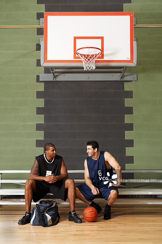 篮球运动员坐在篮球圈下的板凳上图片素材