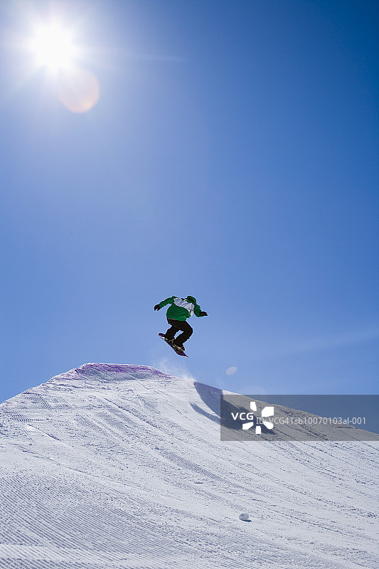 男子在滑雪板上跳跃图片素材